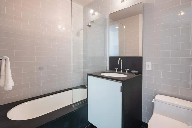 a bathroom with a sink a toilet a mirror and shower