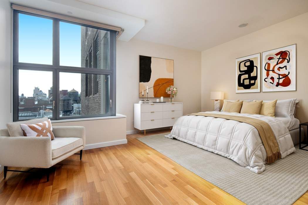 240 Park Avenue South, Unit 14B Manhattan, NY 10003 - Photo 4 of 12 a bedroom with a bed and a large window