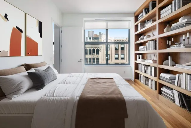 a bedroom with a bed and a book shelf