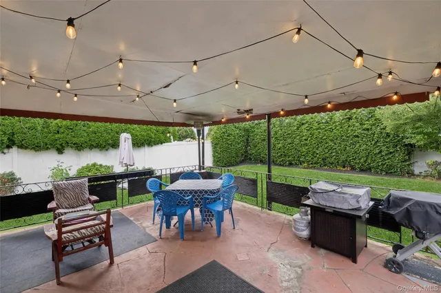 a view of a patio with a table chairs and a backyard
