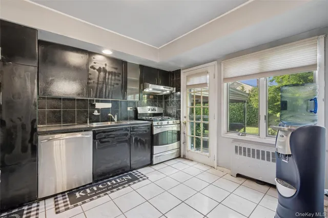 a kitchen with granite countertop a refrigerator and a stove top oven