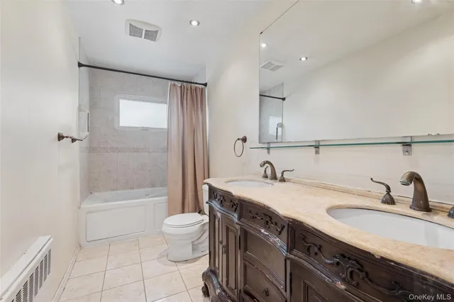 a bathroom with a sink a toilet and a large mirror