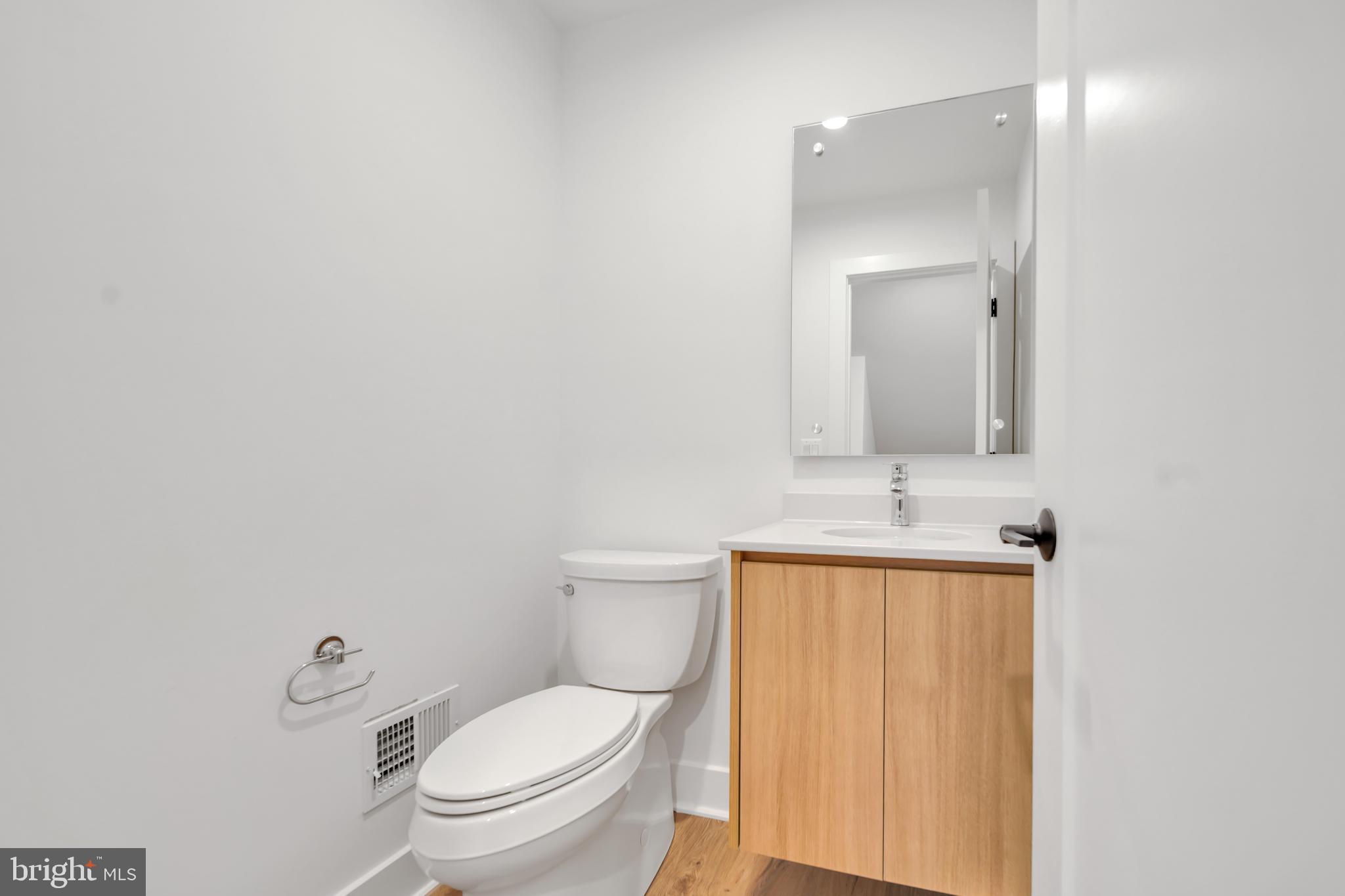 5420 Goshawk Alley Bethesda, MD 20816 - Photo 14 of 57 a bathroom with a toilet a sink and mirror