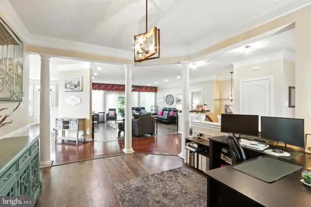 a view of a dining room and livingroom with furniture wooden floor a chandelier