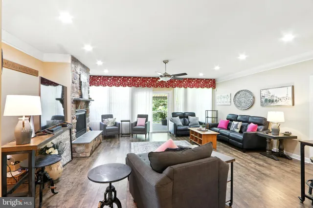 a living room with furniture fireplace and a large window
