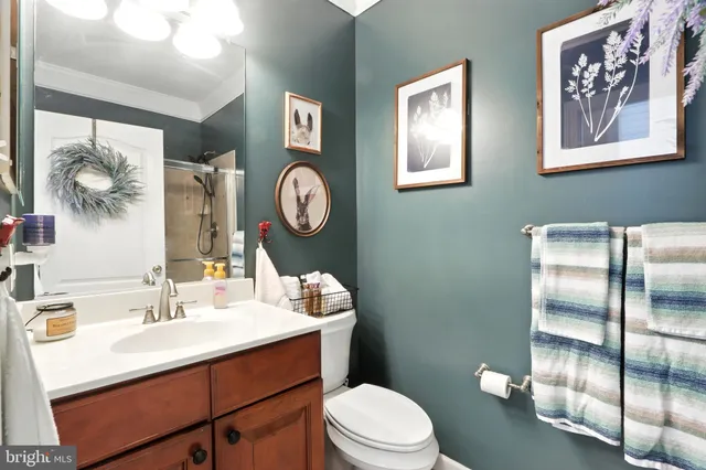 a bathroom with a toilet sink vanity and mirror