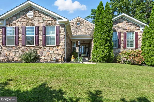 a view of a brick house with a large windows and a yard