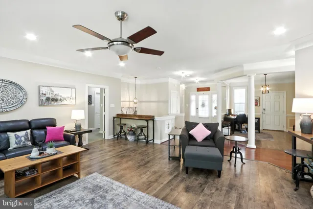 a living room with furniture and a dining table with wooden floor