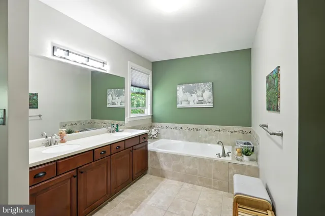 a bathroom with a tub a sink and mirror