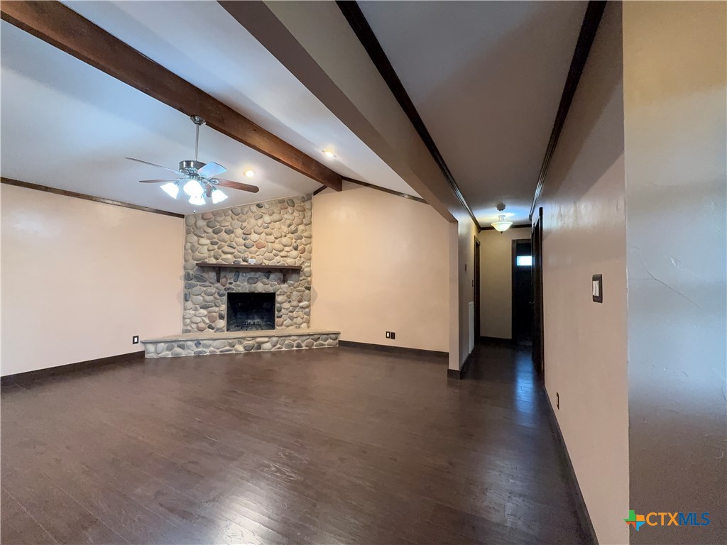 2243 Old Goliad Road Victoria, TX 77905 - Photo 12 of 47 a view of an empty room with wooden floor and a kitchen