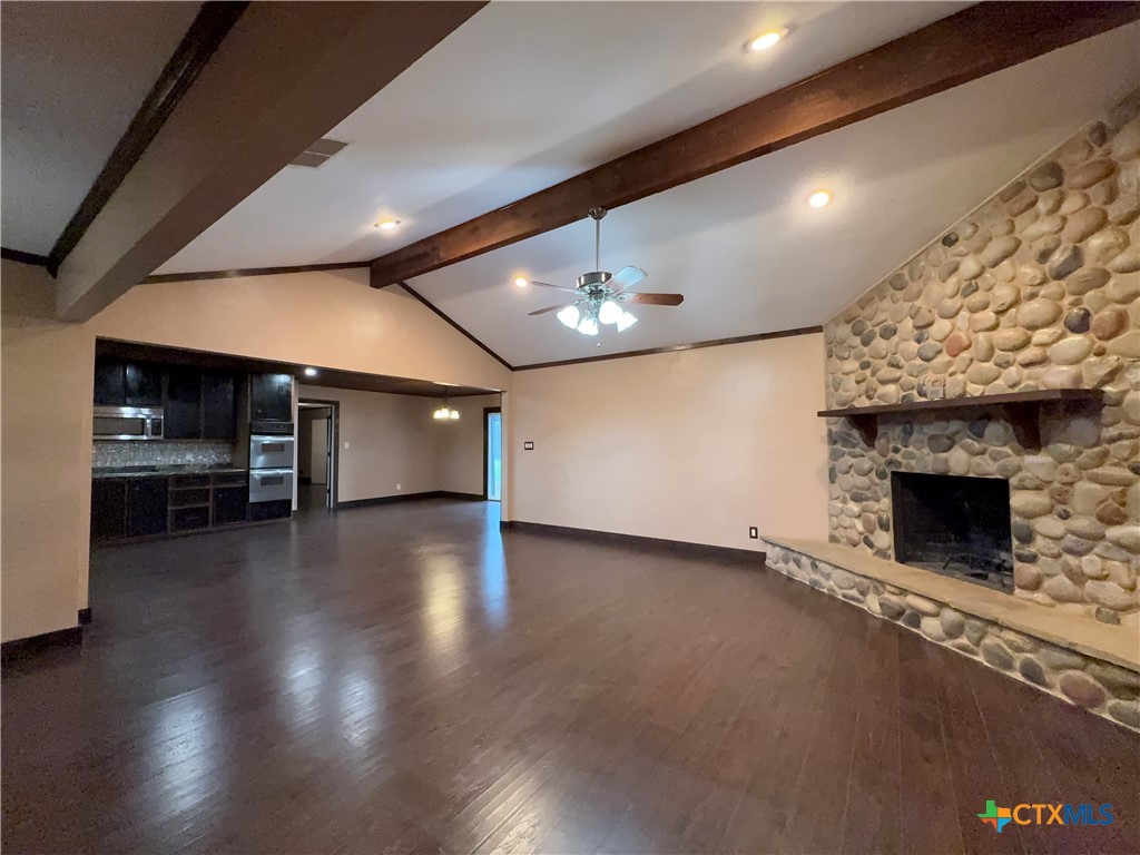 2243 Old Goliad Road Victoria, TX 77905 - Photo 13 of 47 a view of an empty room with wooden floor a fireplace and a window