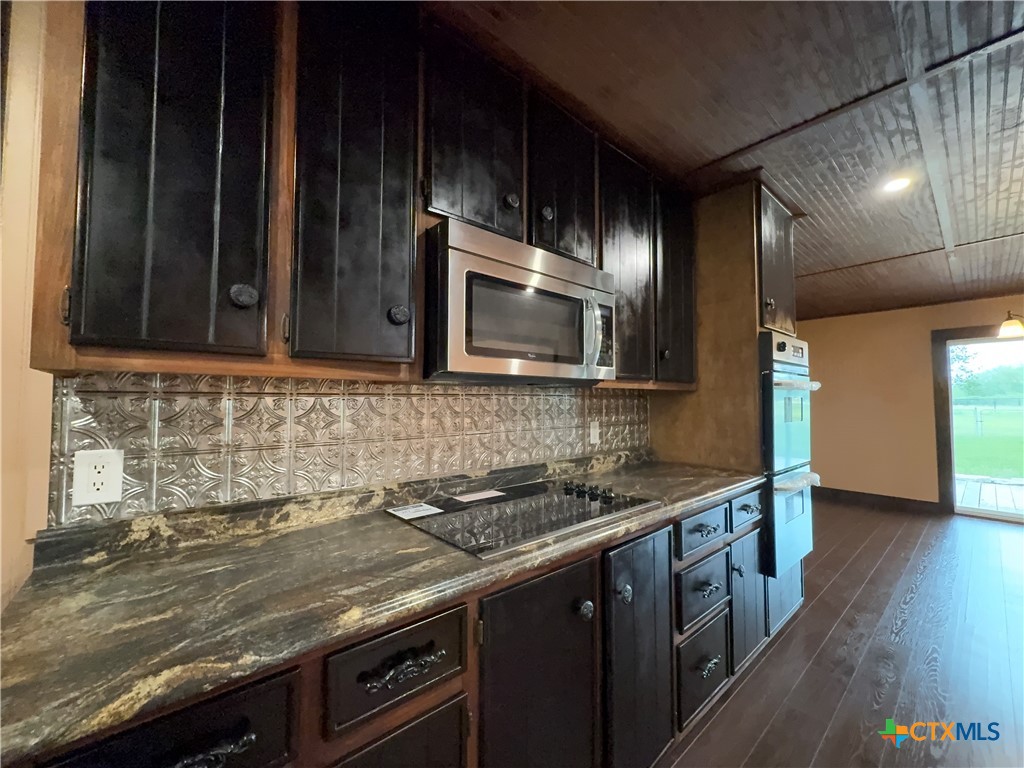 2243 Old Goliad Road Victoria, TX 77905 - Photo 17 of 47 a kitchen with granite countertop stainless steel appliances a stove sink and microwave