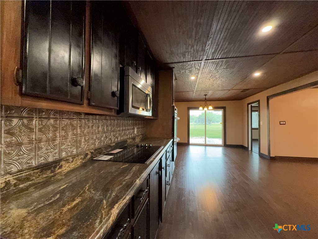 2243 Old Goliad Road Victoria, TX 77905 - Photo 19 of 47 a kitchen with granite countertop stainless steel appliances and wooden floor
