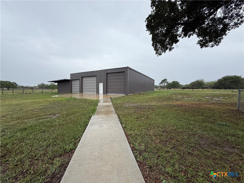 2243 Old Goliad Road Victoria, TX 77905 - Photo 40 of 47 a backyard of a house with lots of green space and lake view in back