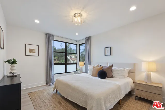 a bedroom with a large bed and a chandelier