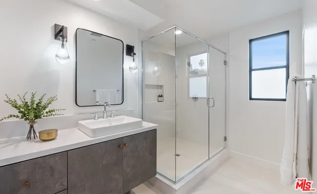 a bathroom with a shower sink and mirror