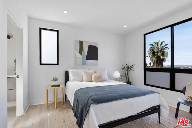 a bedroom with a large bed and a painting on the wall