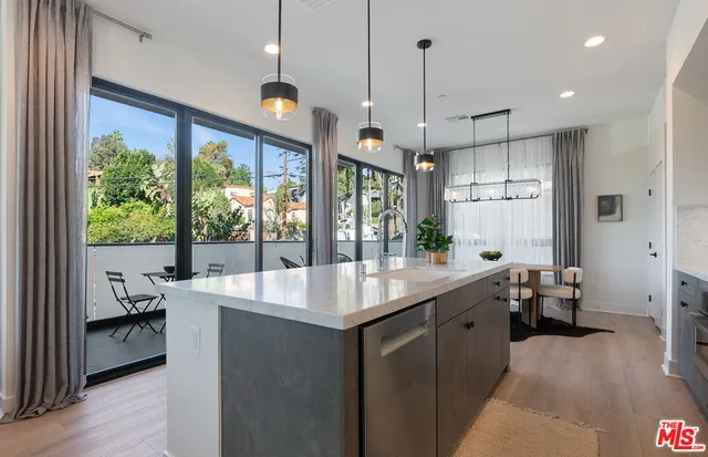 a kitchen with kitchen island a large window in it