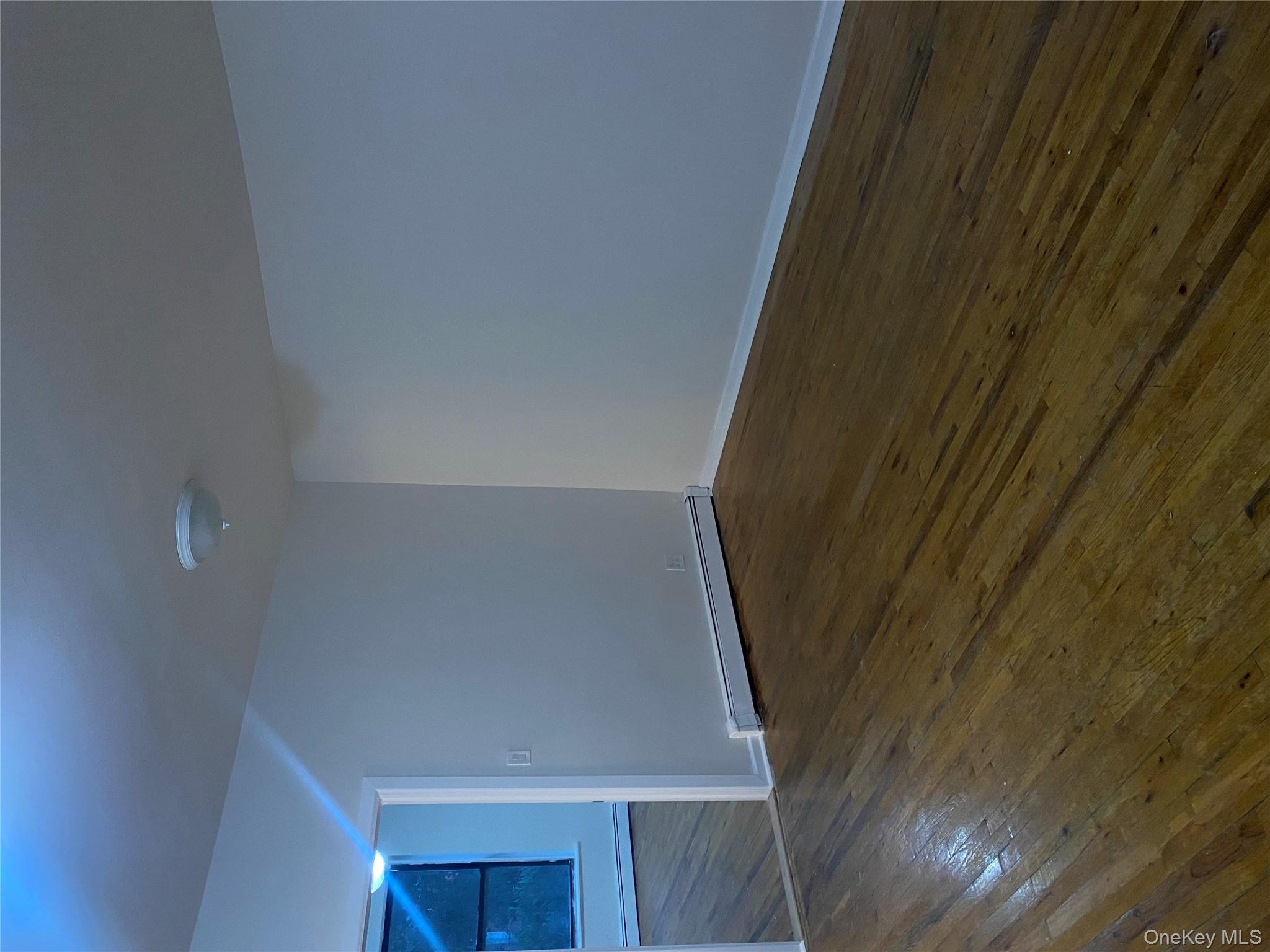 61-57 Eliot Avenue, Unit 1 Queens, NY 11379 - Photo 2 of 5 a view of an empty room with wooden floor