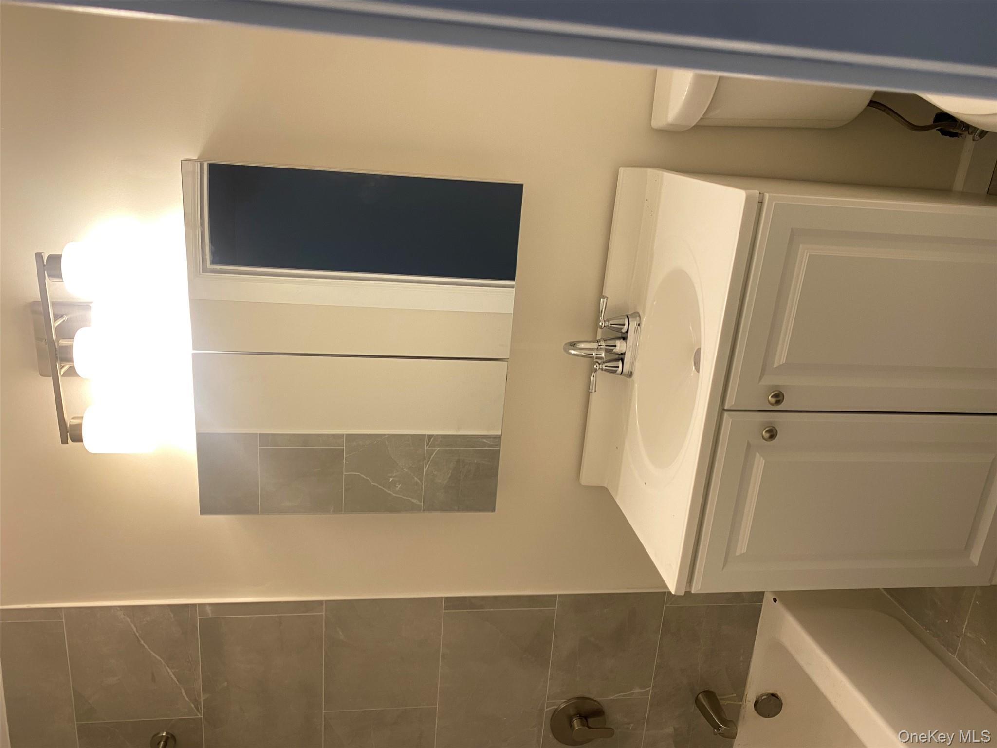 61-57 Eliot Avenue, Unit 1 Queens, NY 11379 - Photo 3 of 5 a bathroom with a sink and a mirror