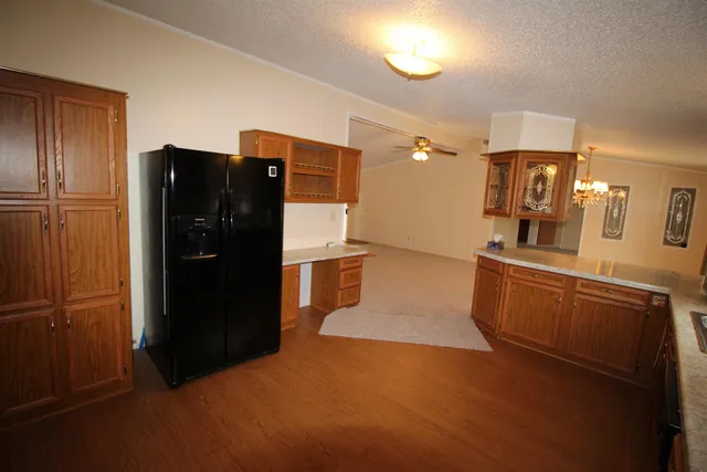 a kitchen with granite countertop a refrigerator and a sink