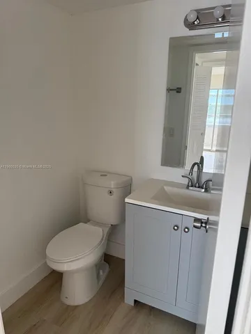 a bathroom with a toilet a sink and mirror