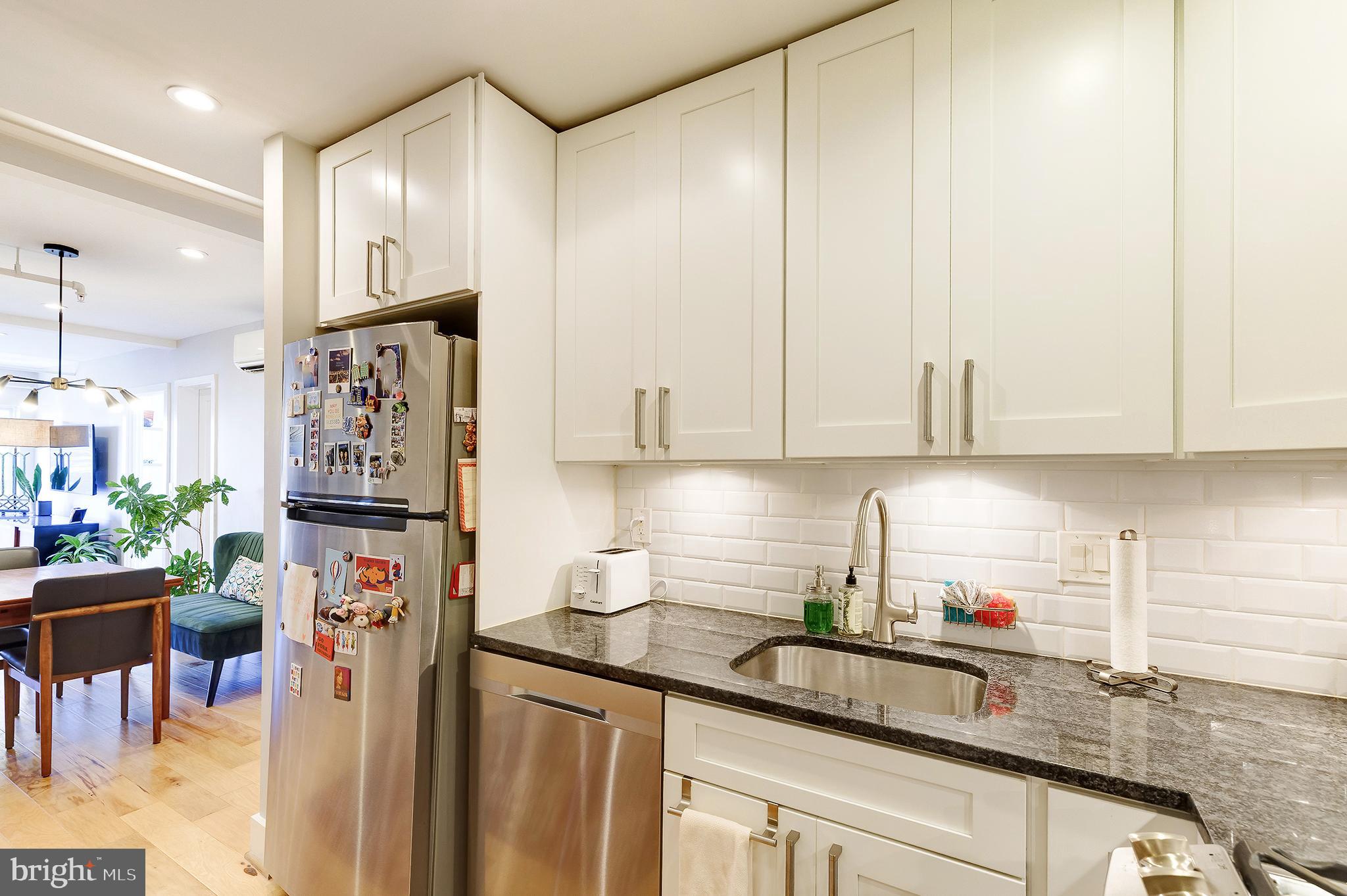 1514 Newton Street Northwest, Unit 301 Washington, DC 20010 - Photo 13 of 30 a kitchen with stainless steel appliances granite countertop a refrigerator sink and cabinets