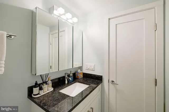 a bathroom with a granite countertop sink and a mirror