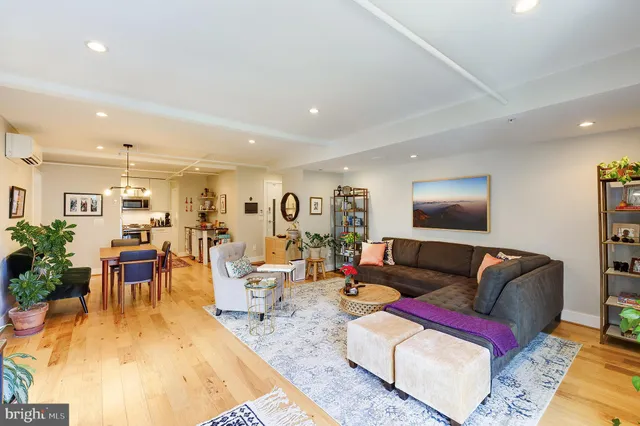 a living room with furniture wooden floor and a table