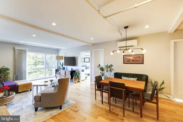 a living room with furniture kitchen view and a large window