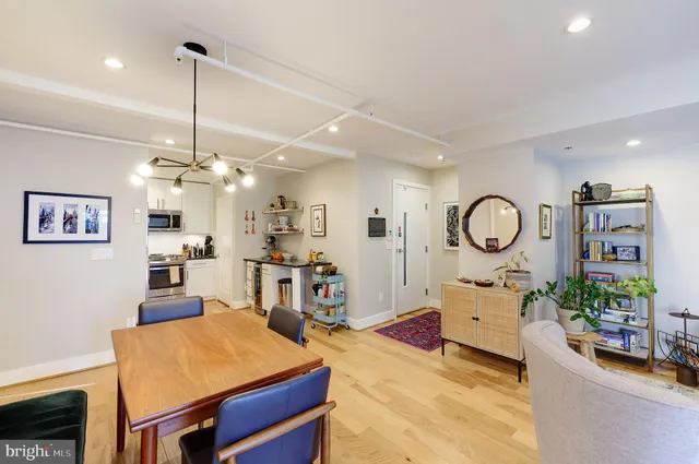 a living room with furniture a dining table and a chandelier