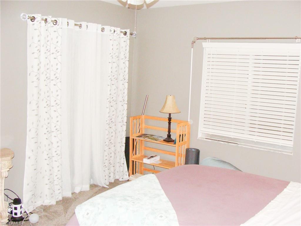 5693 Rattlesnake Hamm Road, Unit A204 Naples, FL 34113 - Photo 11 of 29 a bedroom with a bed and a chair