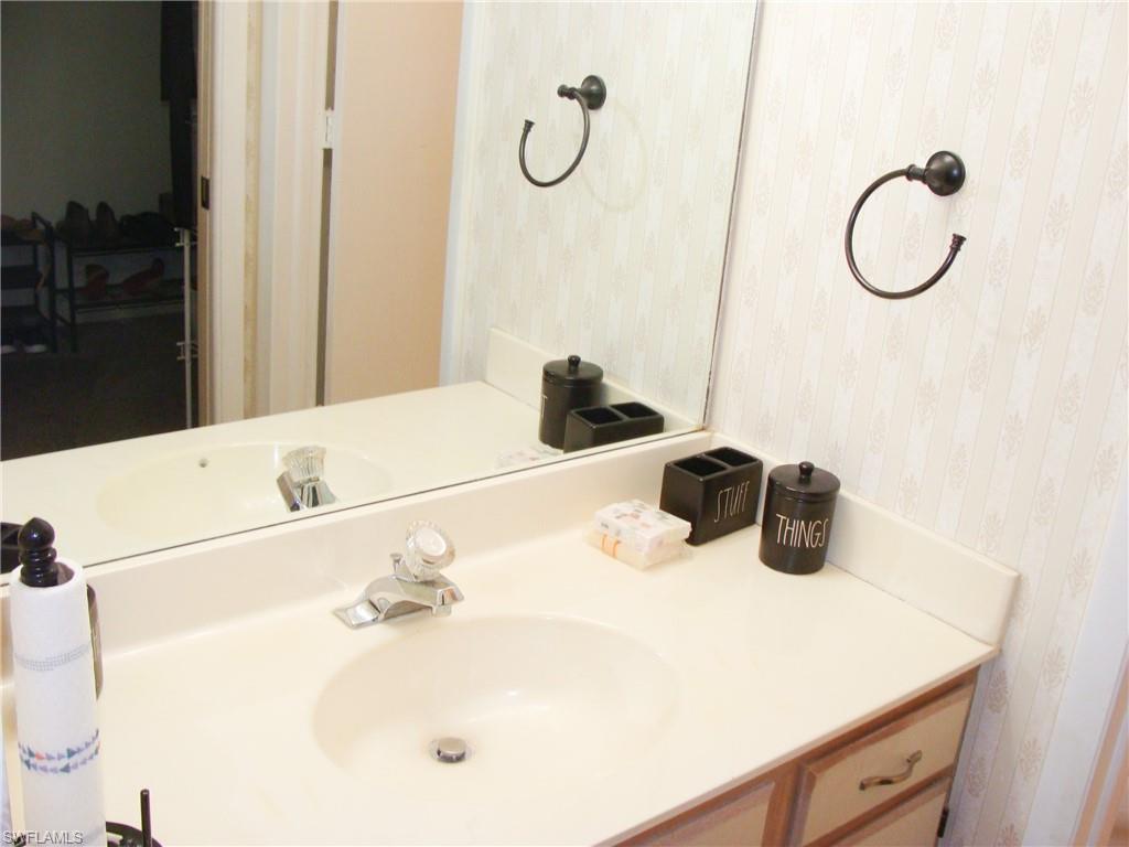 5693 Rattlesnake Hamm Road, Unit A204 Naples, FL 34113 - Photo 12 of 29 a bathroom with a sink and a mirror