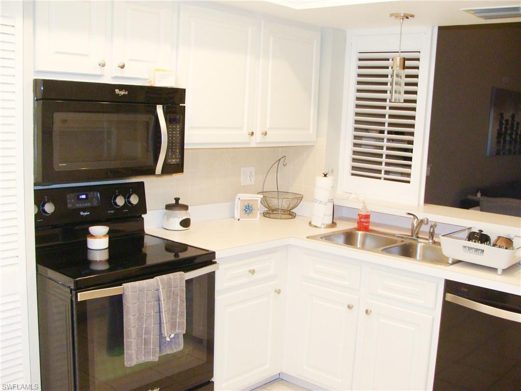 5693 Rattlesnake Hamm Road, Unit A204 Naples, FL 34113 - Photo 2 of 29 a kitchen with stainless steel appliances granite countertop a sink stove and cabinets