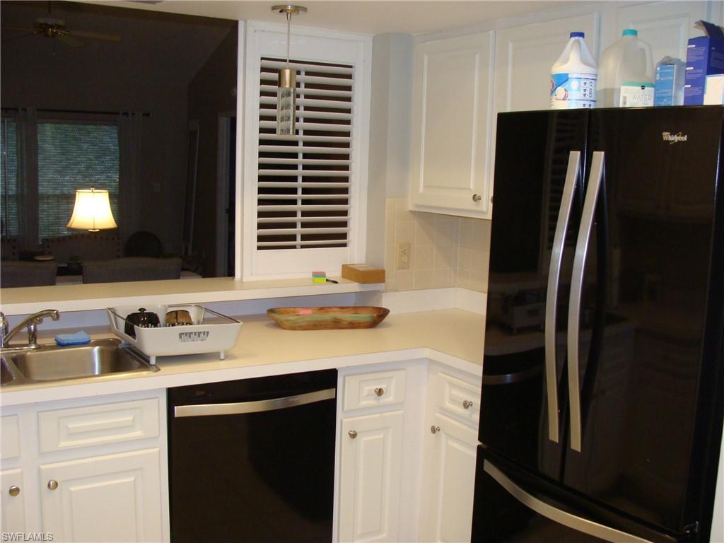 5693 Rattlesnake Hamm Road, Unit A204 Naples, FL 34113 - Photo 4 of 29 a kitchen with a sink and a refrigerator