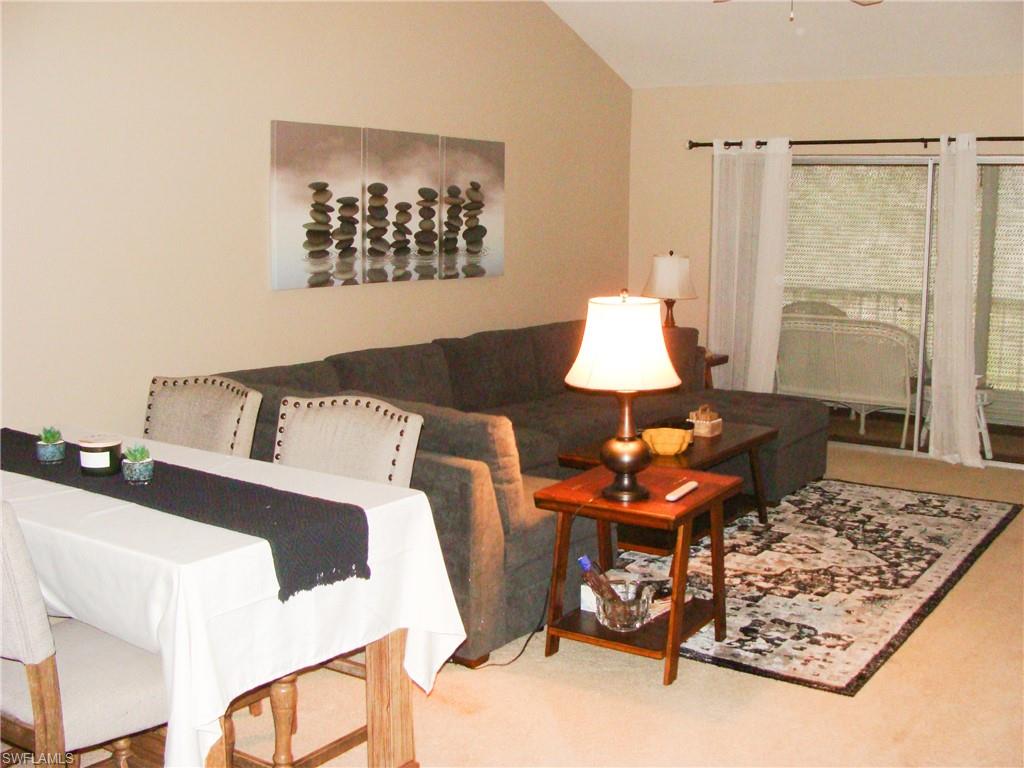 5693 Rattlesnake Hamm Road, Unit A204 Naples, FL 34113 - Photo 5 of 29 a living room with furniture and a table