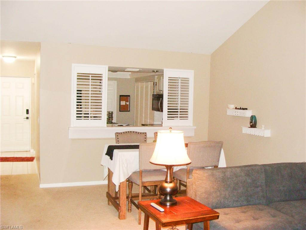 5693 Rattlesnake Hamm Road, Unit A204 Naples, FL 34113 - Photo 7 of 29 a lamp is sitting on a table in a living room