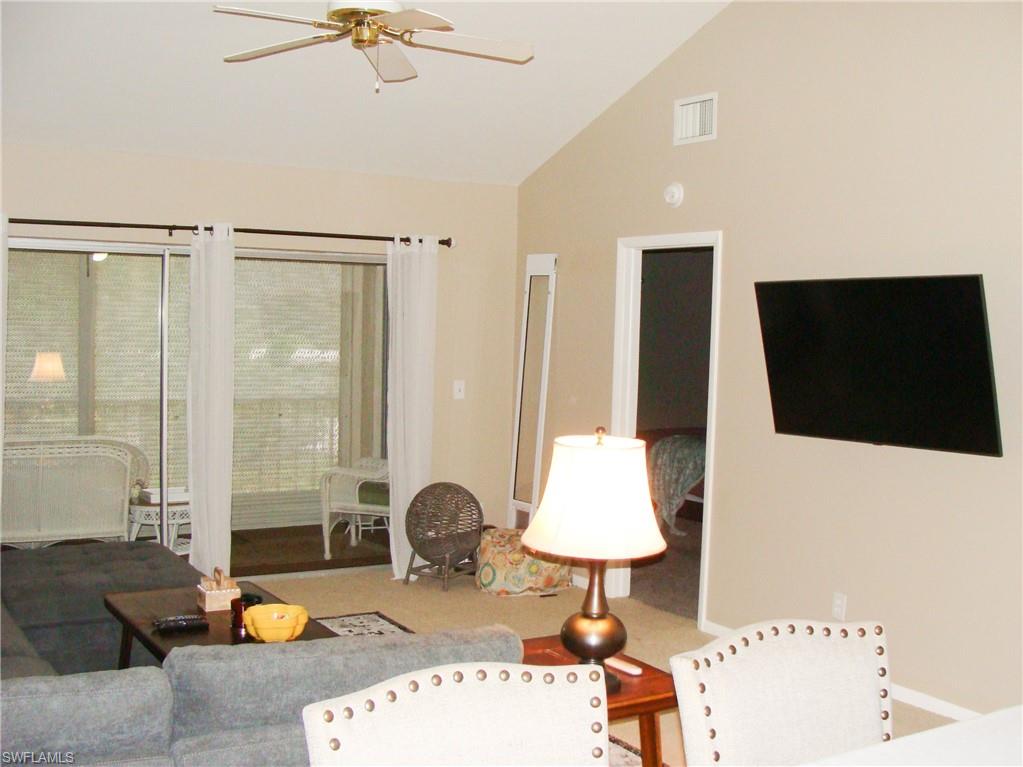 5693 Rattlesnake Hamm Road, Unit A204 Naples, FL 34113 - Photo 8 of 29 a living room with furniture and a flat screen tv