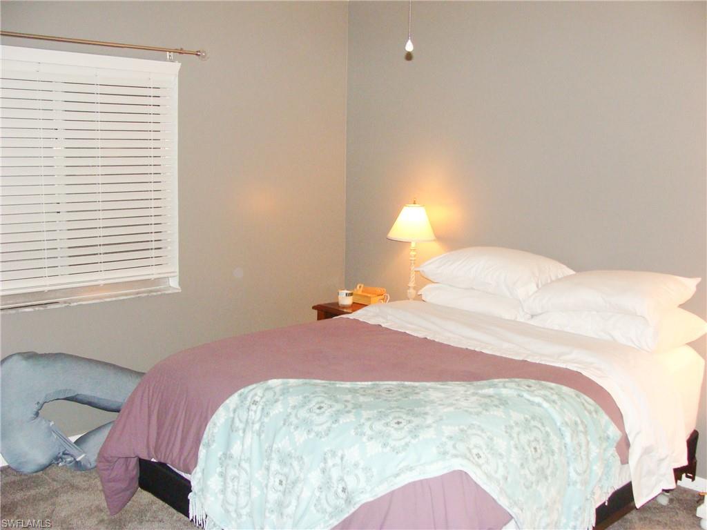 5693 Rattlesnake Hamm Road, Unit A204 Naples, FL 34113 - Photo 10 of 29 a bedroom with a bed and a window