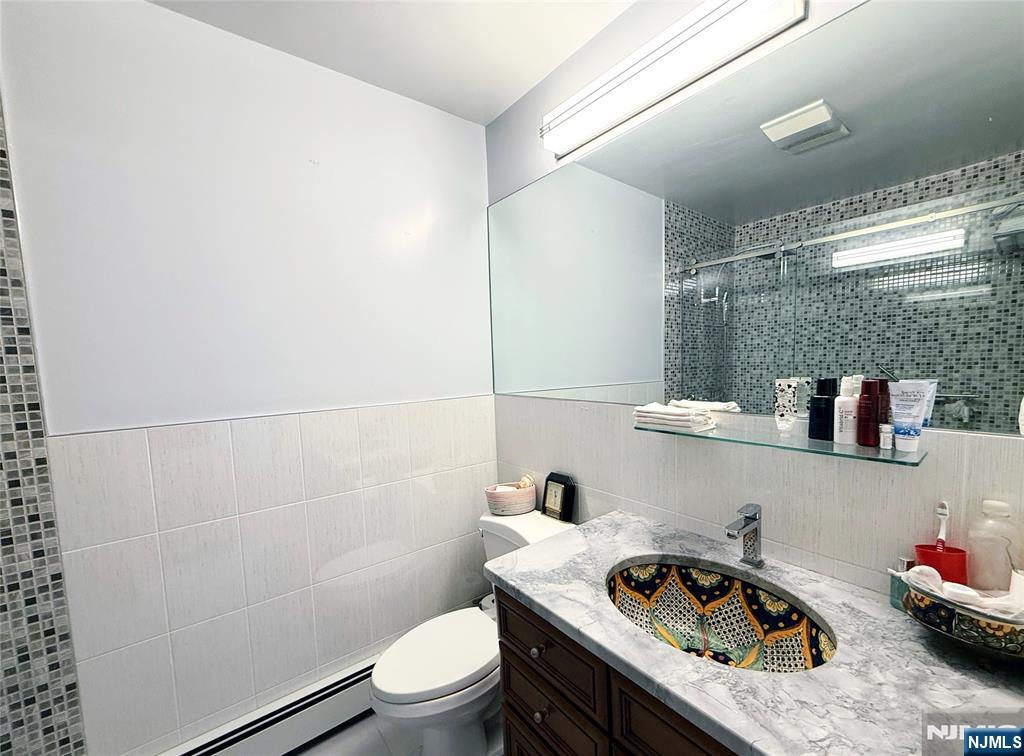 216 Cedar Lane Closter, NJ 07624 - Photo 3 of 15 a bathroom with a sink a toilet and shower