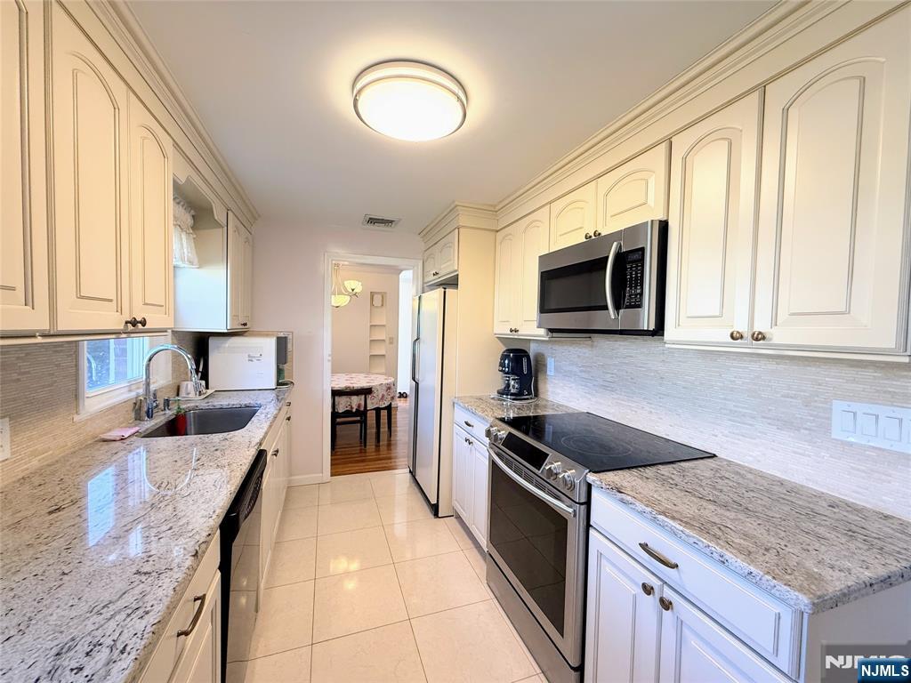 216 Cedar Lane Closter, NJ 07624 - Photo 5 of 15 a kitchen with granite countertop stainless steel appliances a stove microwave and sink