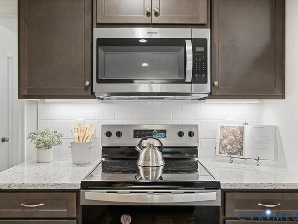 a kitchen with stainless steel appliances granite countertop wooden cabinets a sink and a stove