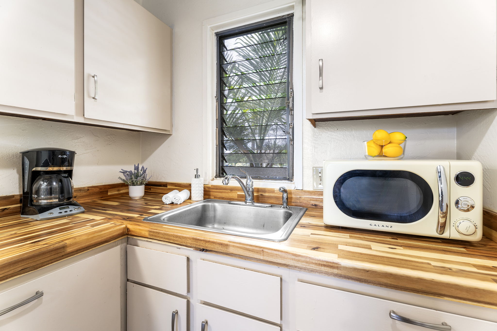 76-6259 Alii Drive, Unit 332 Kailua-Kona, HI 96740 - Photo 11 of 21 a kitchen with a sink and a stove with wooden floor