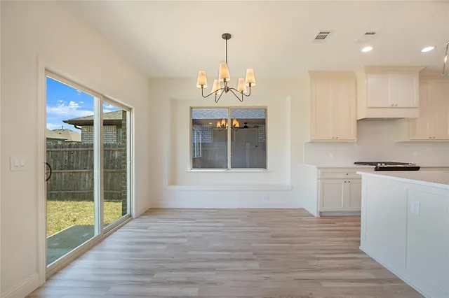a view of a kitchen with wooden floor and a window
