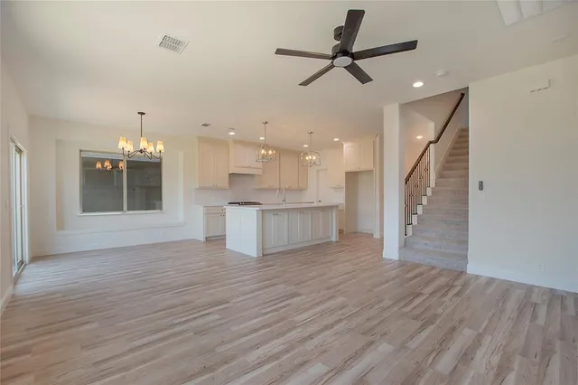 a view of a kitchen with wooden floor and a ceiling fan