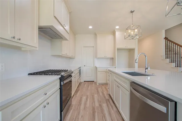 a kitchen with a sink stove and cabinets