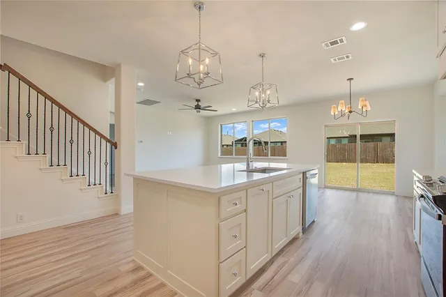 a kitchen with stainless steel appliances granite countertop a sink stove and wooden floor