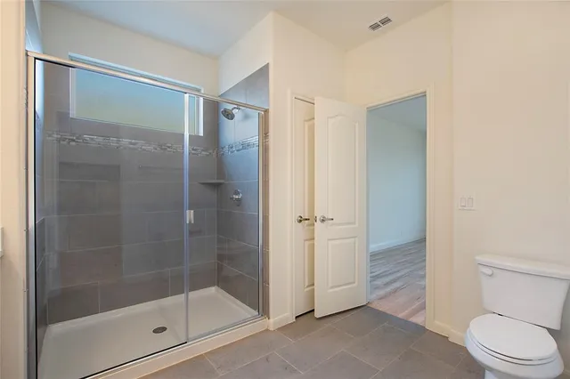 a bathroom with a shower a toilet and a sink