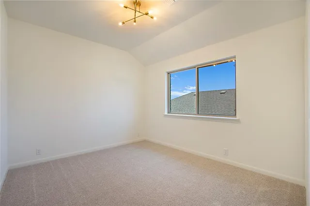 an empty room with a chandelier fan