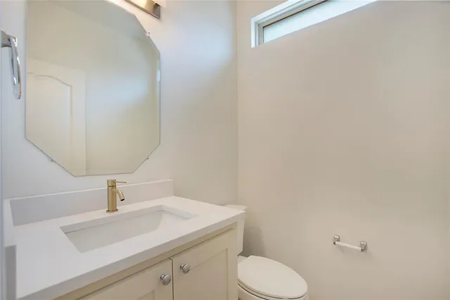 a bathroom with a sink a toilet and mirror